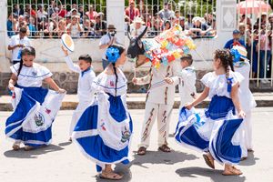 Kids in vibrant traditional outfits perform a cultural dance in Santa Rosa de Lima, El Salvador's festival.