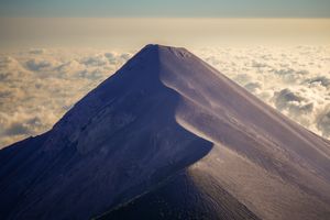 Breathtaking aerial view of Acatenango Volcano peak above the clouds in Guatemala.